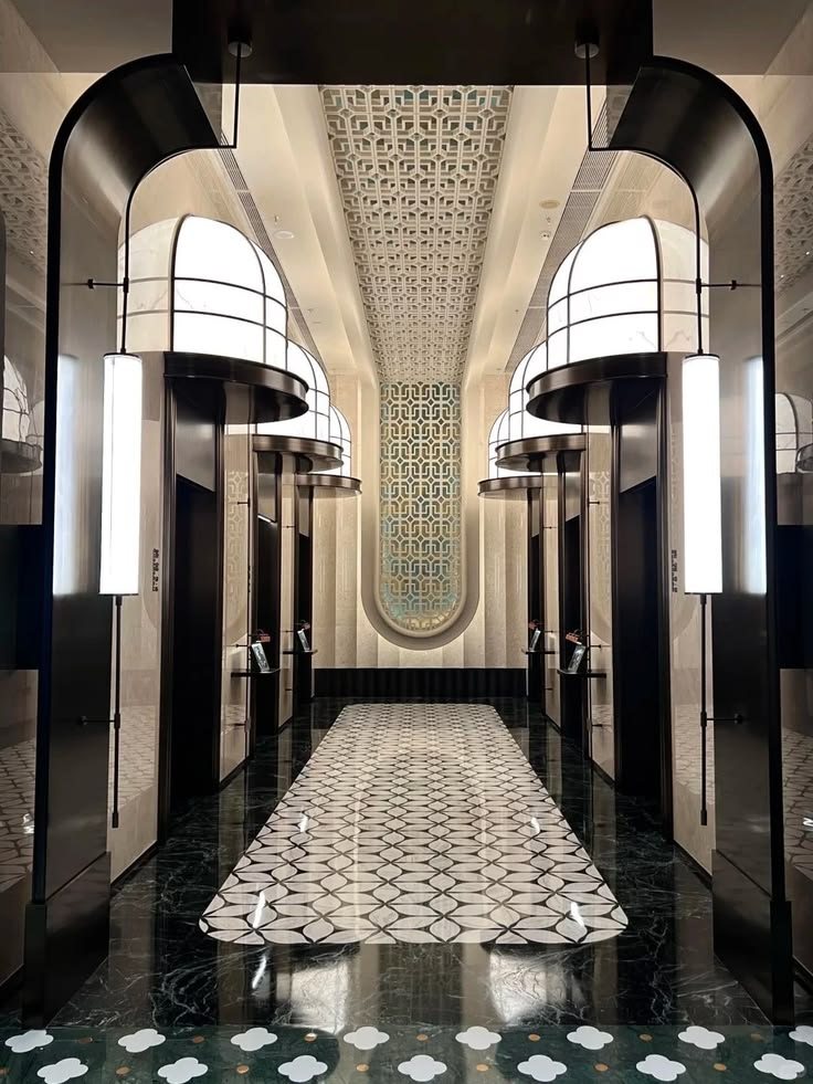Ảnh tham khảo Neo Deco — hành lang thang máy vòm cong, đèn hình trụ, sàn marble hoạ tiết hình học